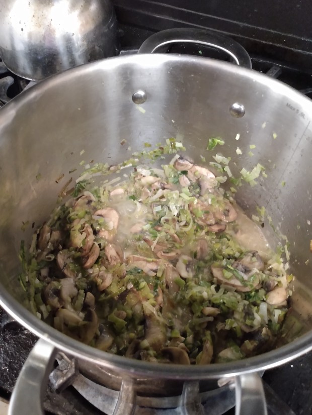 Photo of the contents of the soup pot halfway into making the soup recipe, with the cooked leeks and mushrooms.